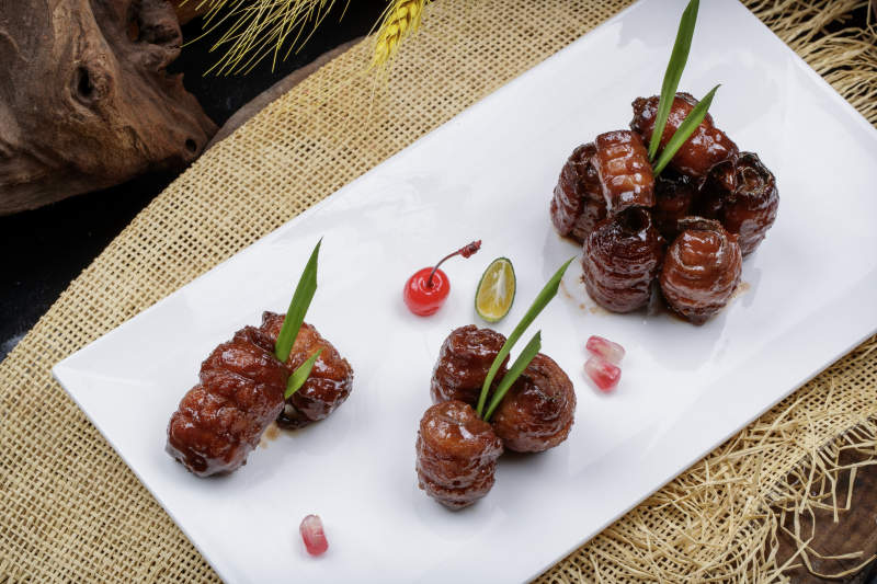 烟熏蜜汁带鱼卷摆放在麻布垫子上图片