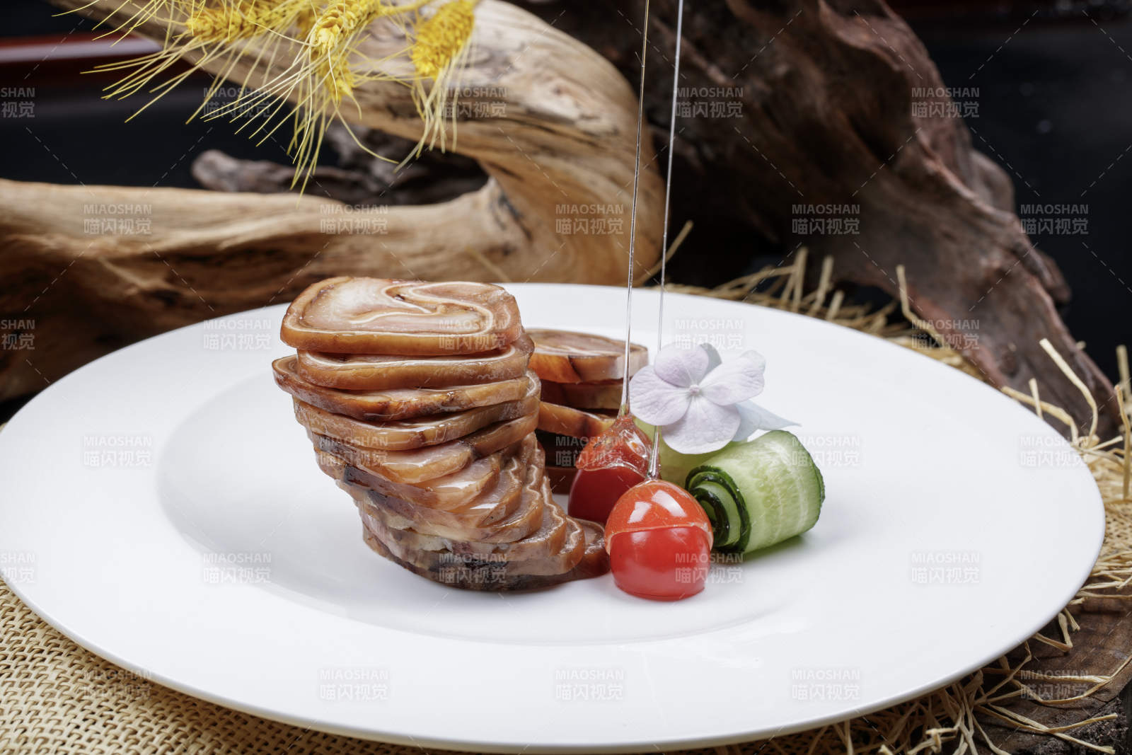 白色圆盘装的烟熏猪耳卷摆放在麻布垫子上图片