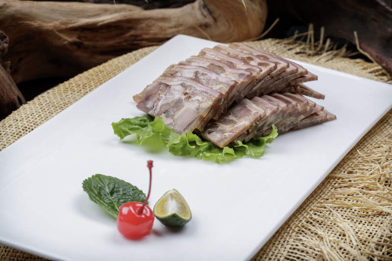 长方形瓷盘装的熏肘花摆放在麻布垫子上图片