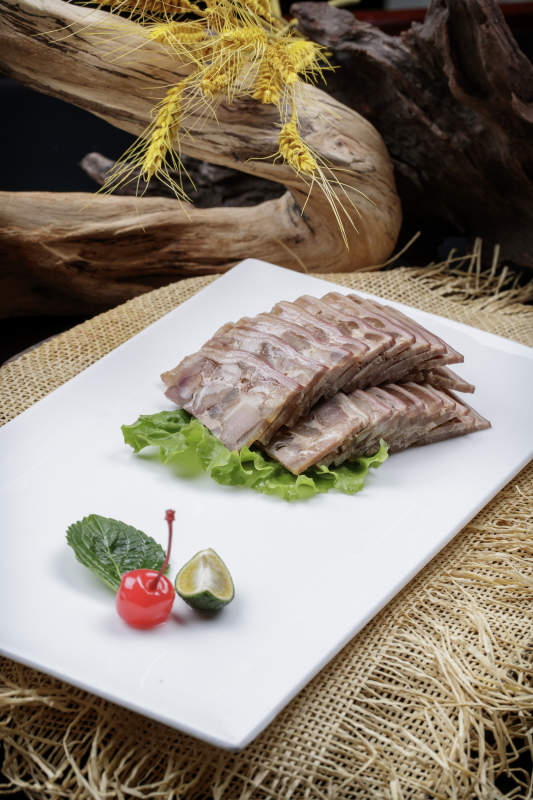 长方形瓷盘装的熏肘花摆放在麻布垫子上图片