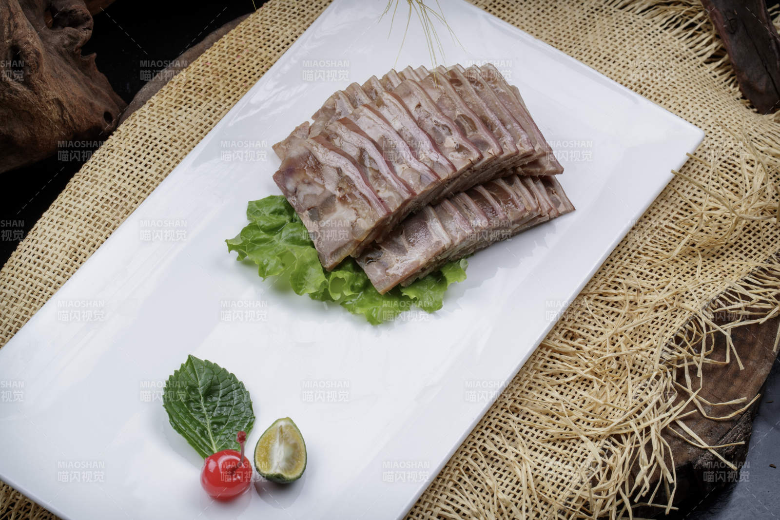 长方形瓷盘装的熏肘花摆放在麻布垫子上图片