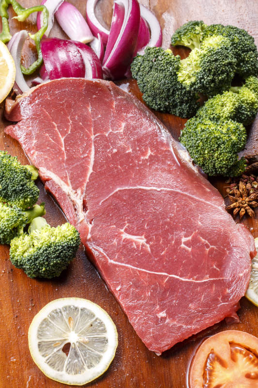 牛臀肉摆放在木质砧板上图片