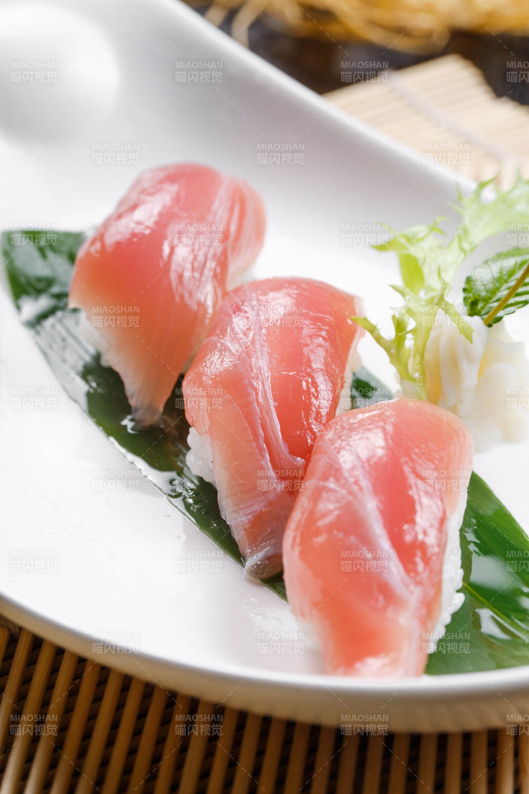 金枪鱼手握寿司摆放在寿司帘上图片