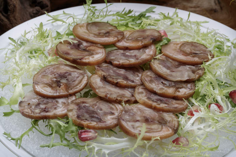 精美餐具装的五香肘花卷切片图片