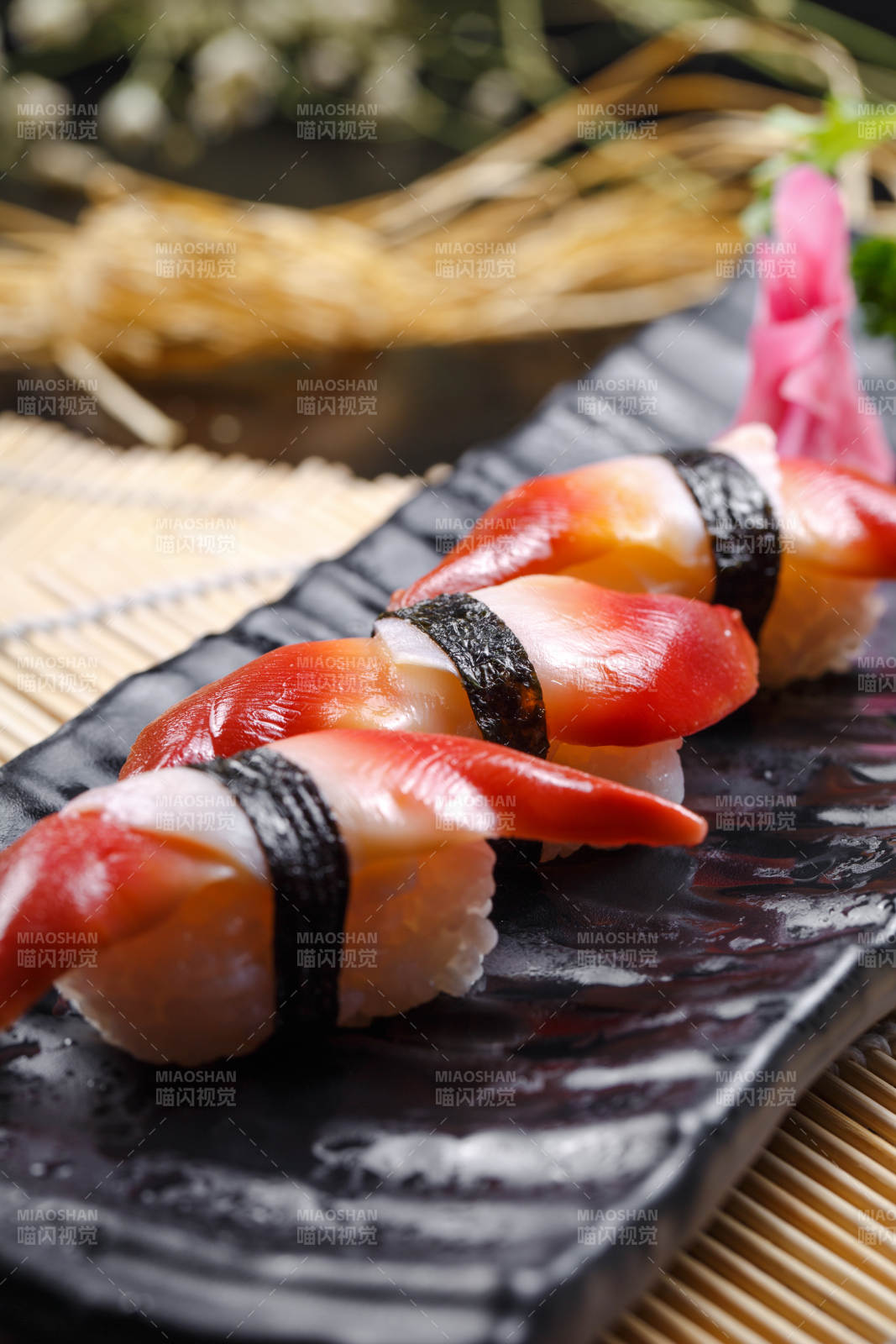 北极贝手握寿司摆放在寿司帘上图片