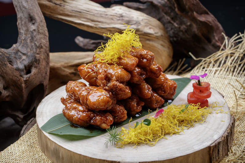 砧板上的的糖醋里脊摆放在麻布垫子上图片