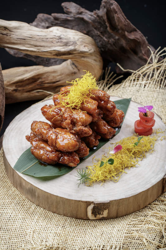 砧板上的的糖醋里脊摆放在麻布垫子上图片