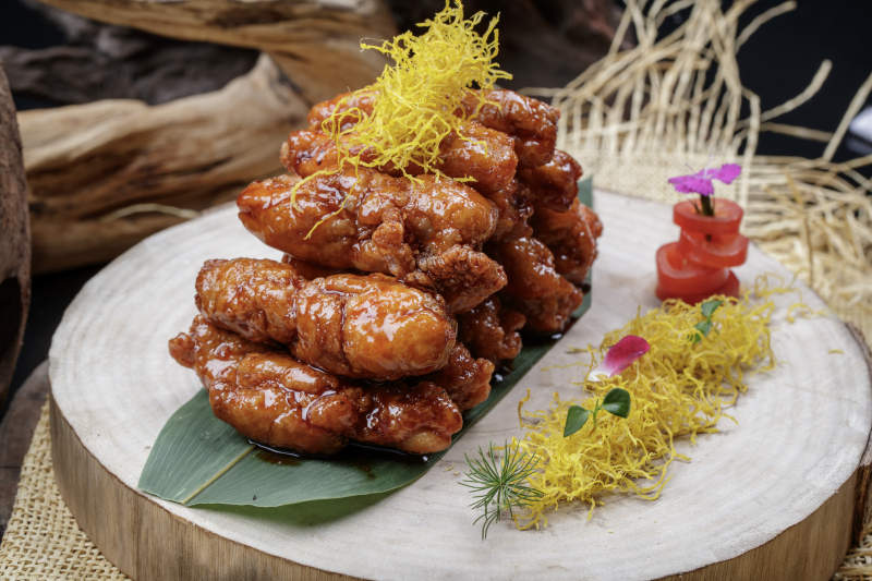 砧板上的的糖醋里脊摆放在麻布垫子上图片