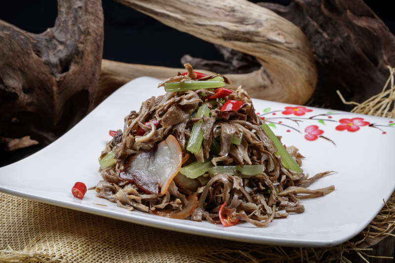 梅花图案白瓷盘装的五花肉烧鲜松蘑片图片