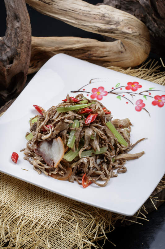 梅花图案白瓷盘装的五花肉烧鲜松蘑片图片