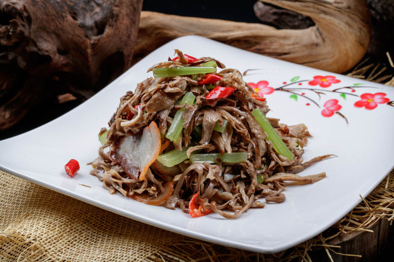 梅花图案白瓷盘装的五花肉烧鲜松蘑片图片