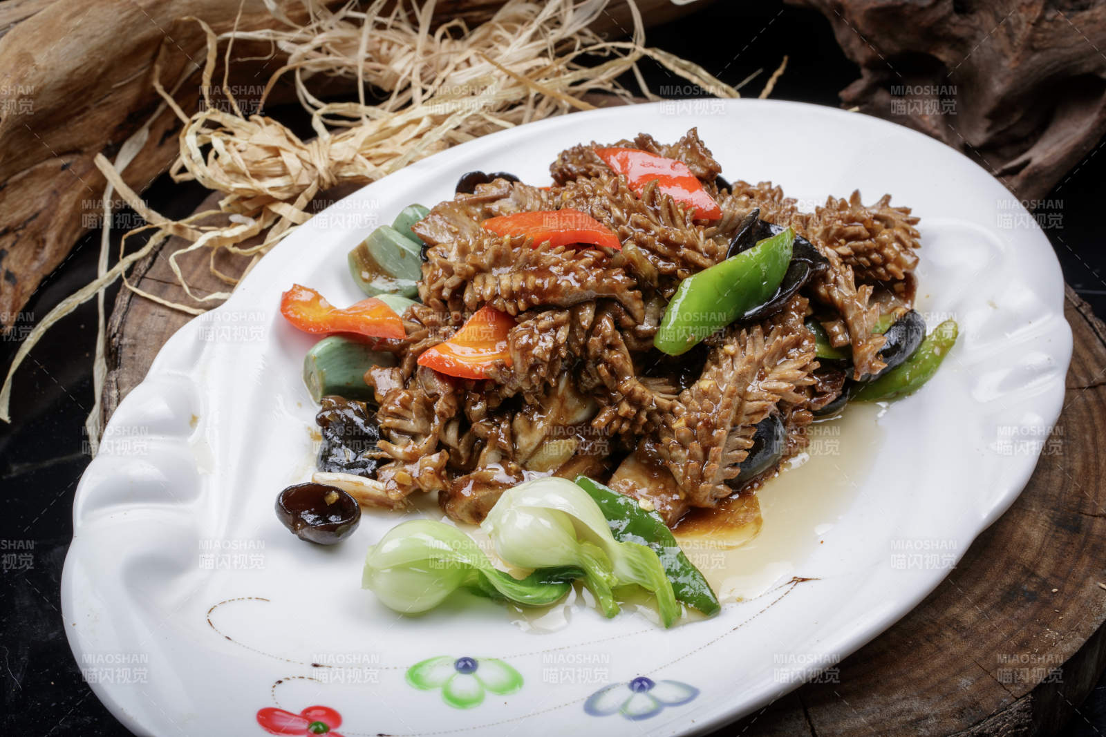 椭圆瓷盘装的腊八蒜炒腰花摆放在樟木砧板上图片