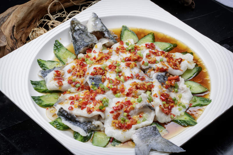 清蒸剁椒海梭鱼摆放在黑色背景上图片