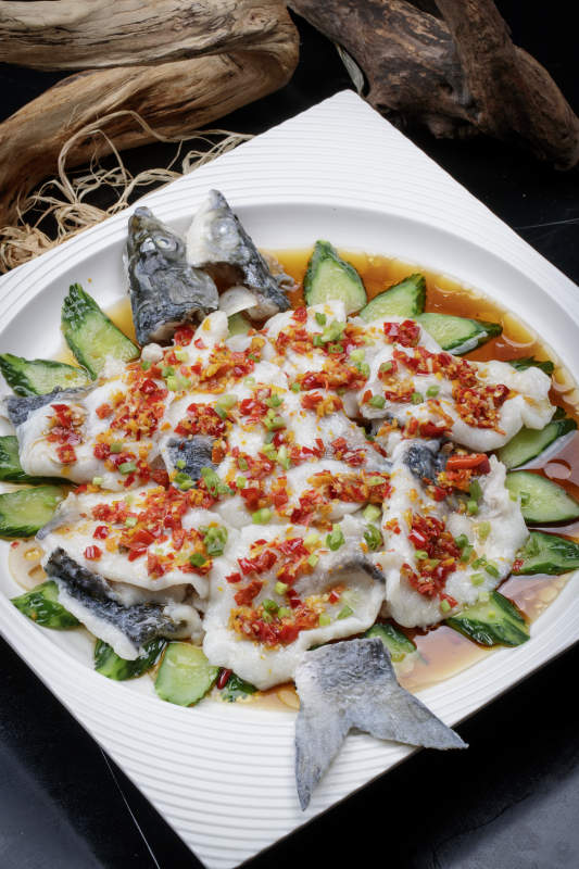 清蒸剁椒海梭鱼摆放在黑色背景上图片