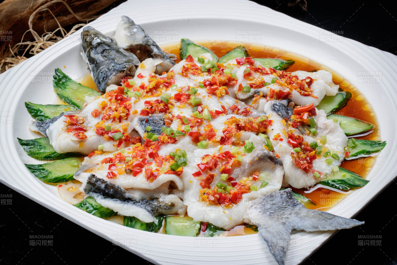 清蒸剁椒海梭鱼摆放在黑色背景上图片