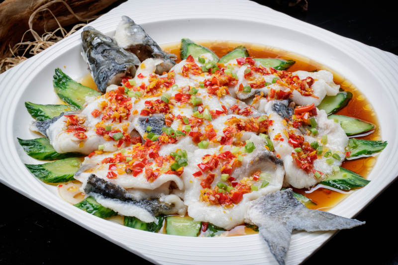 清蒸剁椒海梭鱼摆放在黑色背景上图片