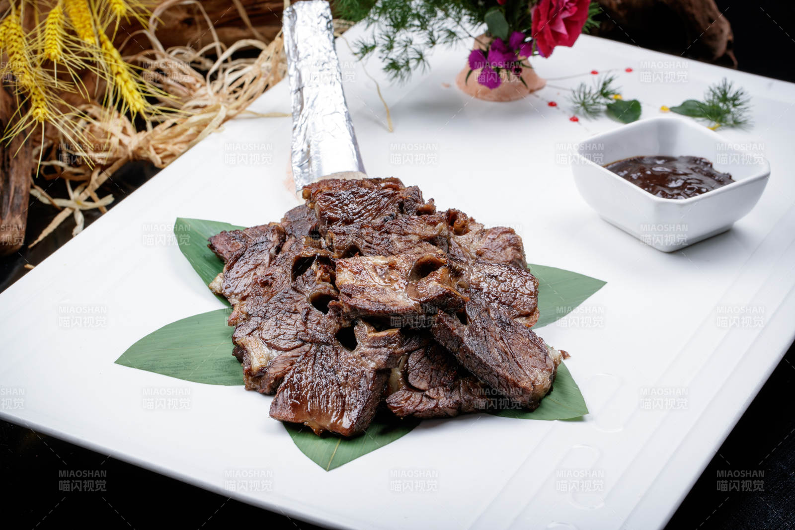 方形瓷盘装的炭烤牛肋排摆放在黑色背景上图片