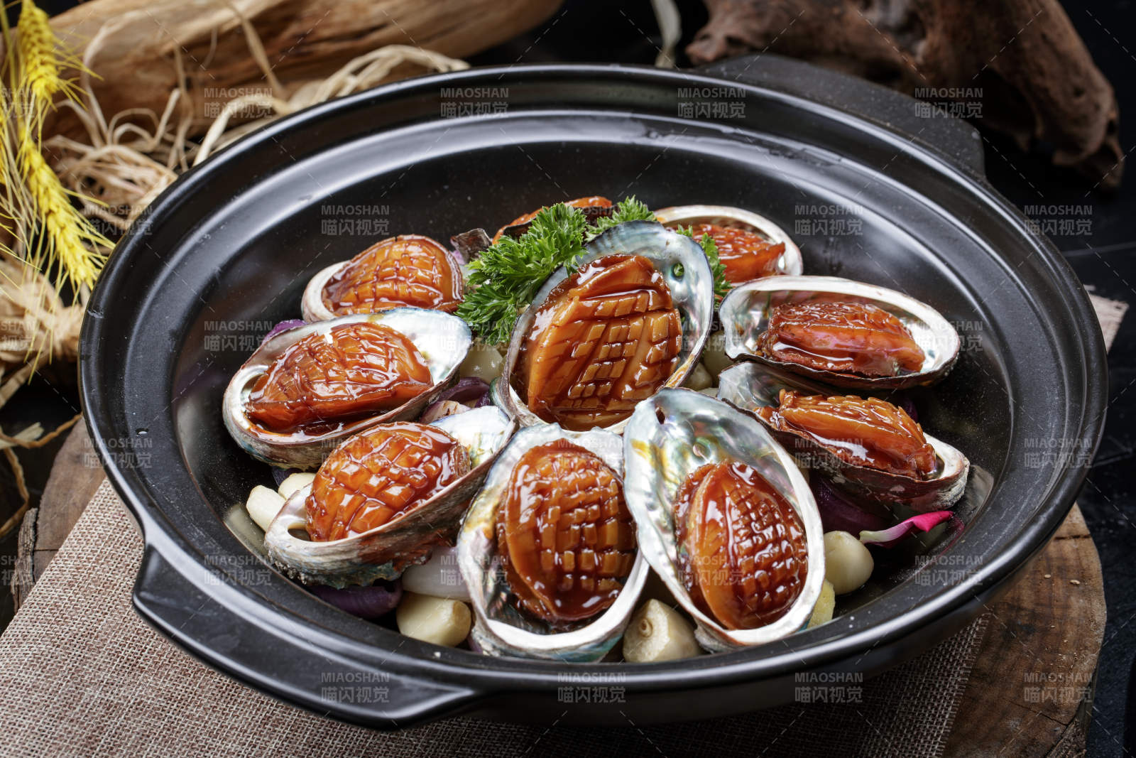 蒜焗砂锅鲜鲍鱼摆放在麻布垫子上图片