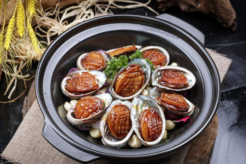 蒜焗砂锅鲜鲍鱼摆放在麻布垫子上图片