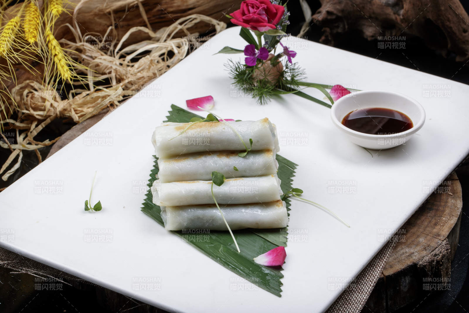 方形瓷盘装的河内肠粉摆放在黑色背景上图片