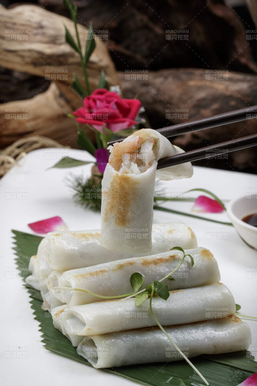 方形瓷盘装的河内肠粉摆放在黑色背景上图片