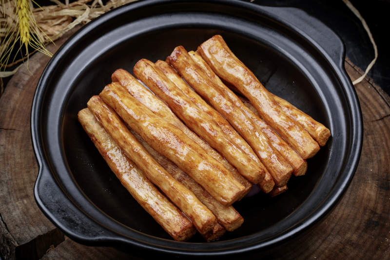 锅焗铁棍长山药摆放在樟木砧板上图片