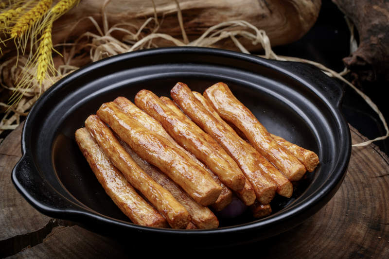 锅焗铁棍长山药摆放在樟木砧板上图片