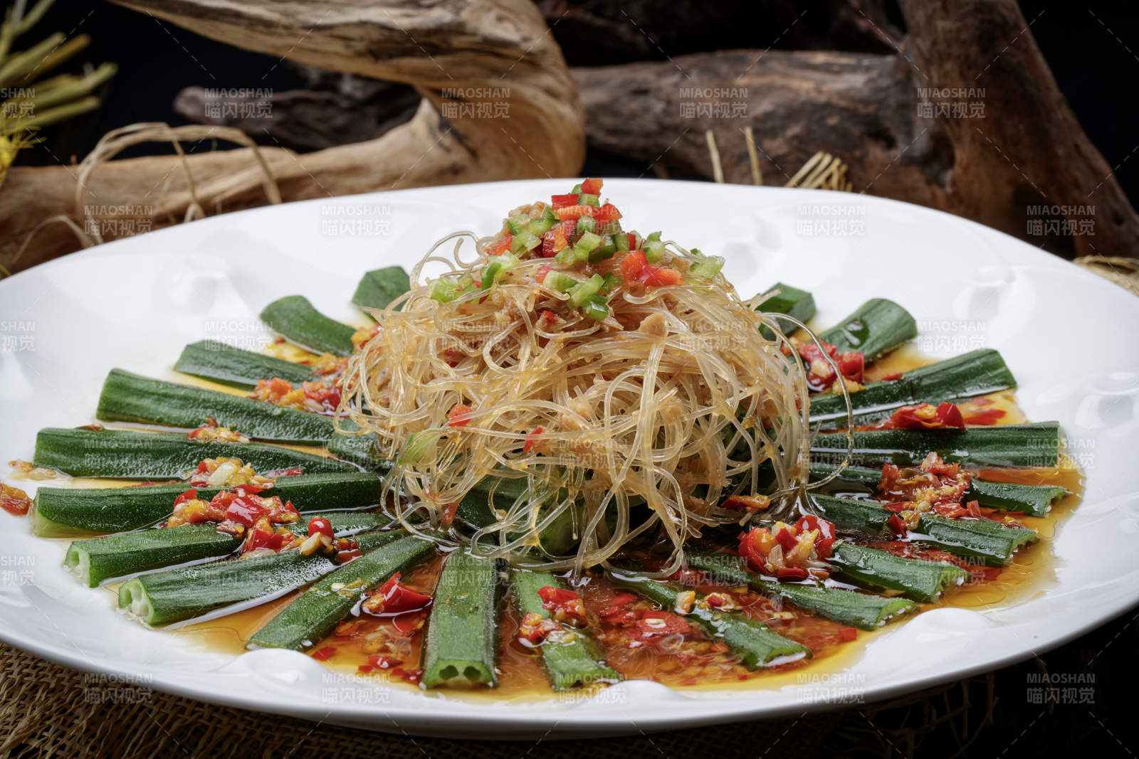 白色瓷盘装的蒜蓉粉丝蒸秋葵图片