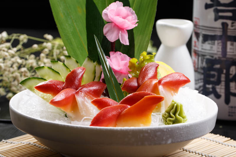 北极贝刺身摆放在寿司帘上图片