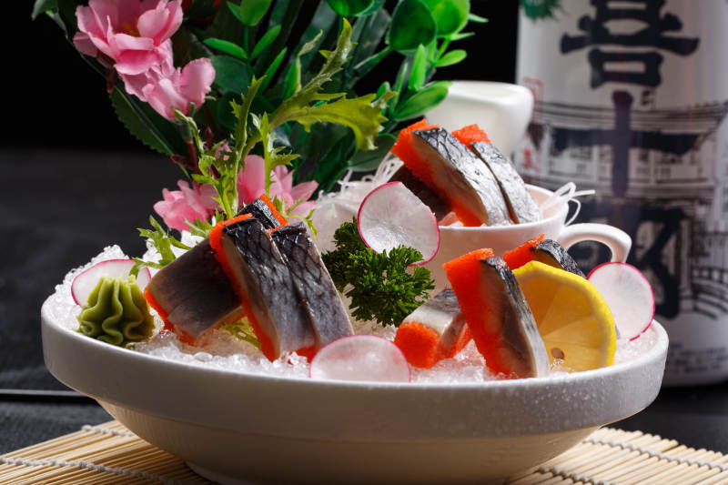 西鳞鱼刺身摆放在寿司帘上图片