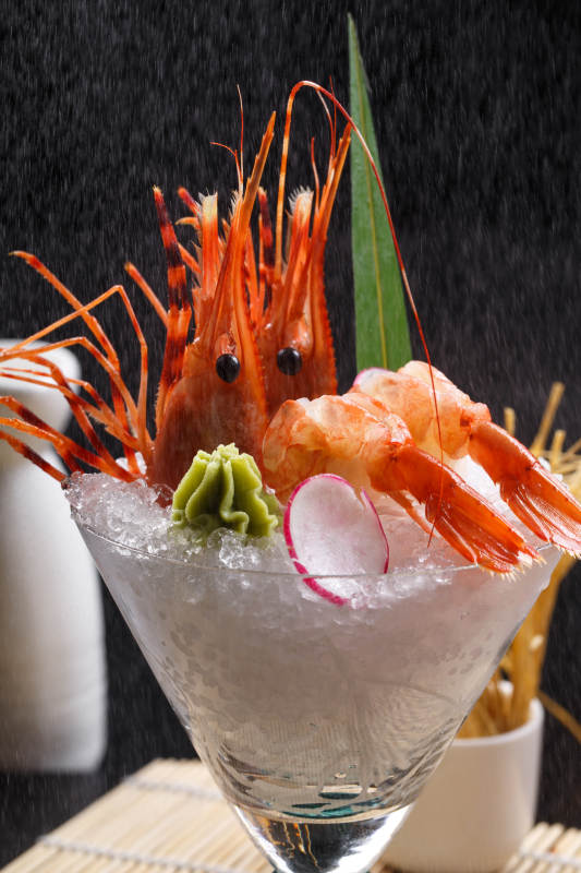 装满碎冰的高脚杯摆放的两只北极甜虾刺身图片