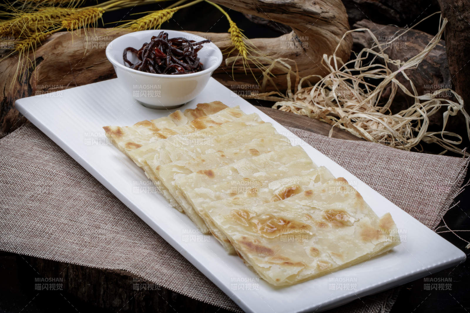老咸菜香酥饼摆放在麻布垫子上图片