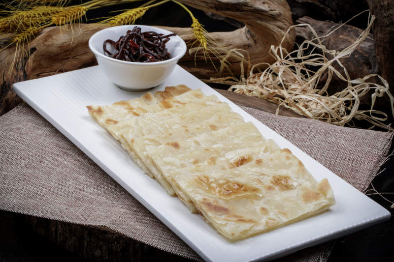 老咸菜香酥饼摆放在麻布垫子上图片