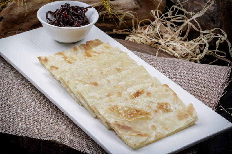 老咸菜香酥饼摆放在麻布垫子上图片