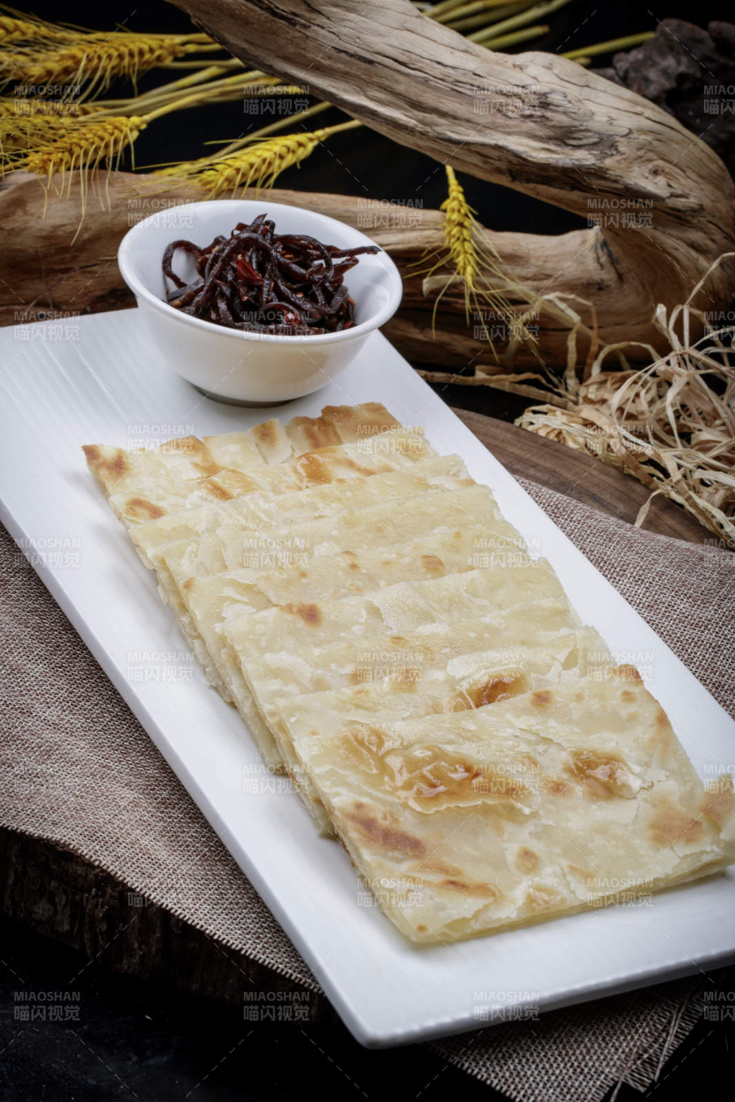 老咸菜香酥饼摆放在麻布垫子上图片
