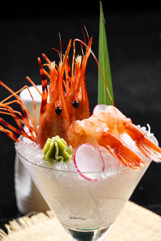 装满碎冰的高脚杯摆放的两只北极甜虾刺身图片