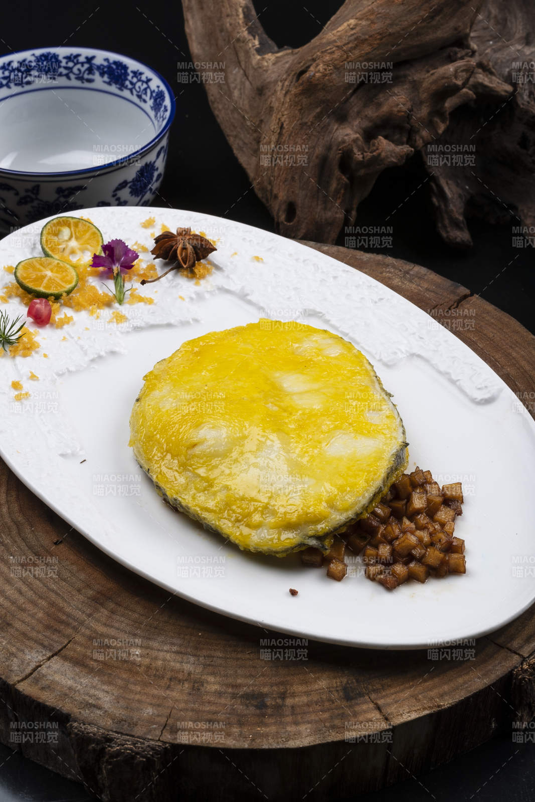 托圆瓷盘装的香煎银鳕鱼摆放在樟木砧板上图片