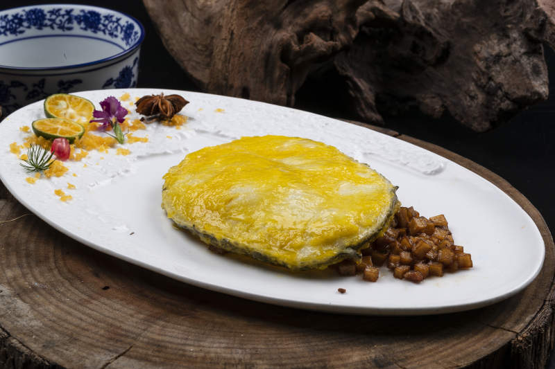 托圆瓷盘装的香煎银鳕鱼摆放在樟木砧板上图片