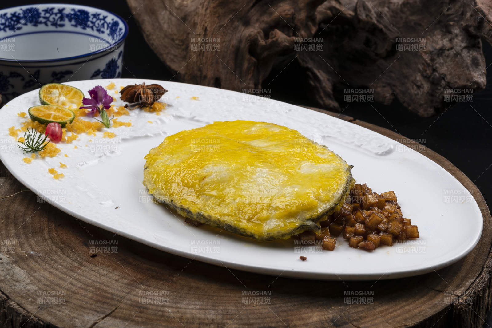 托圆瓷盘装的香煎银鳕鱼摆放在樟木砧板上图片