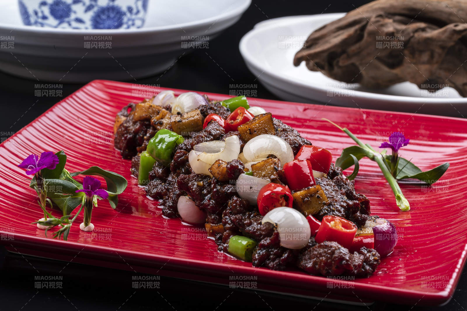 杭椒葱香牛仔粒摆放在黑色背景上图片