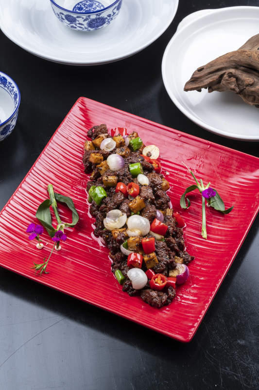 杭椒葱香牛仔粒摆放在黑色背景上图片