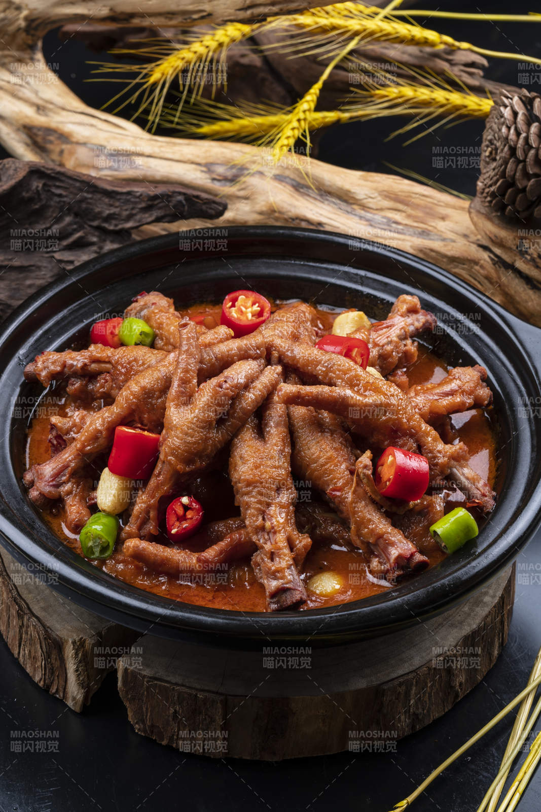 蒜香砂锅煲凤爪摆放在黑色背景上图片