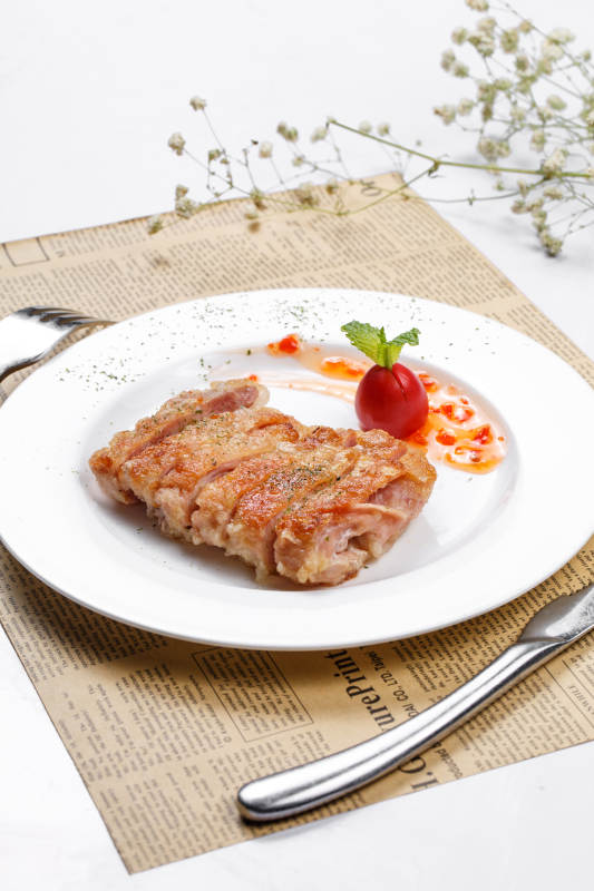 脆皮铁板鸡排摆放在英文包装纸上图片