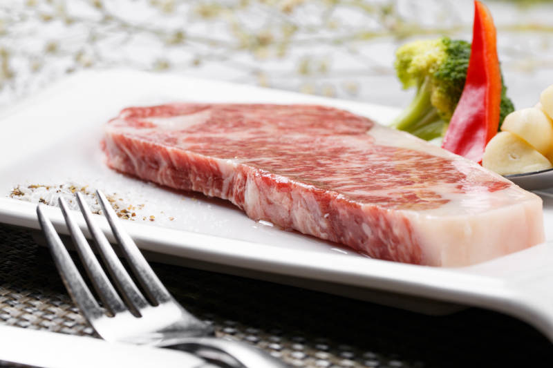 顶级A5A3级雪花牛排摆放在餐垫上图片