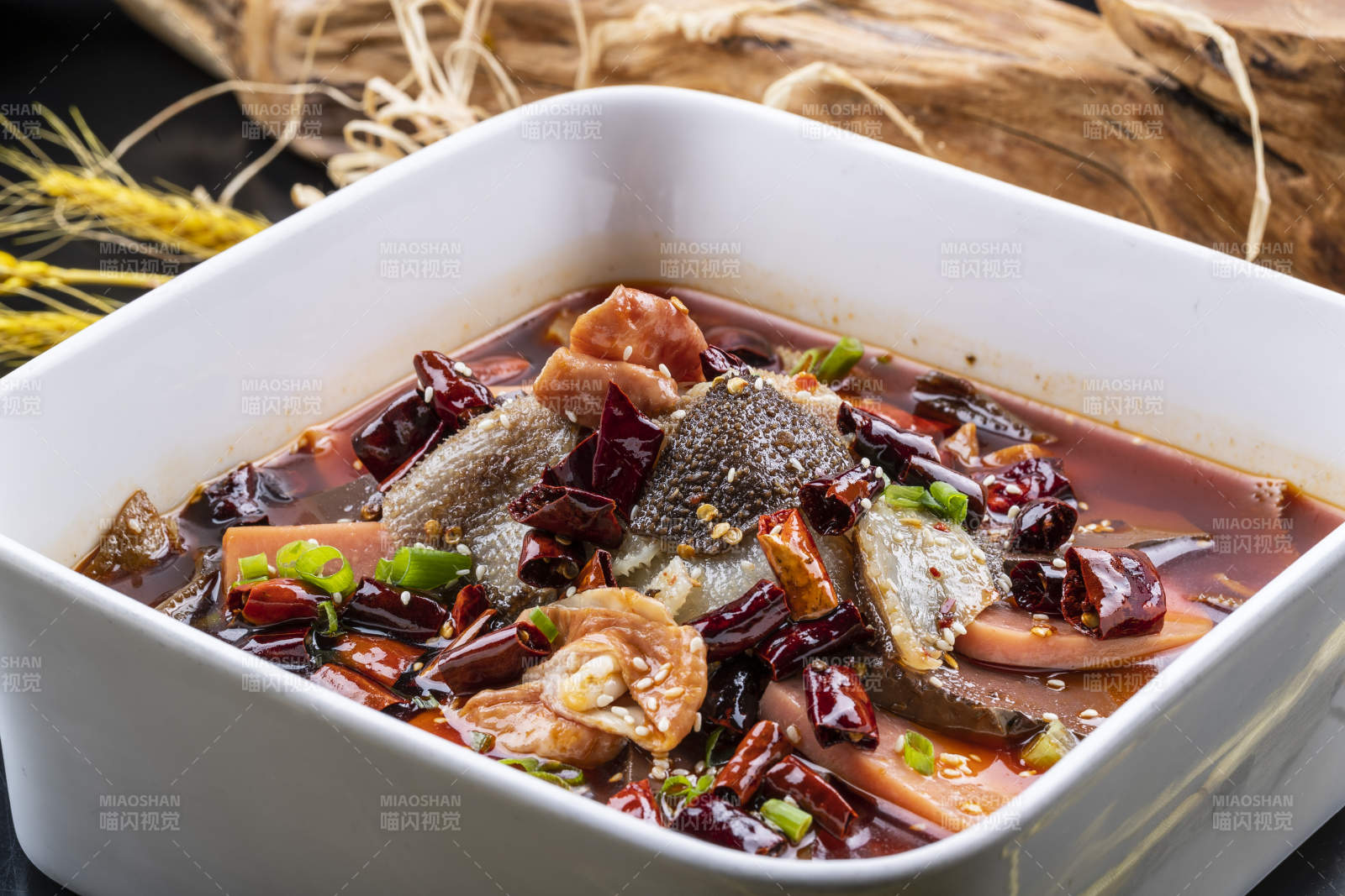 方形汤盆装的川香毛血旺摆放在黑色背景上图片