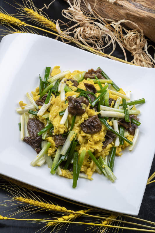 山珍菌韭菜炒鸡蛋摆放在黑色背景上图片