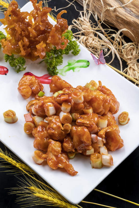 造型奇特的的宫保大虾球摆放在黑色背景上图片