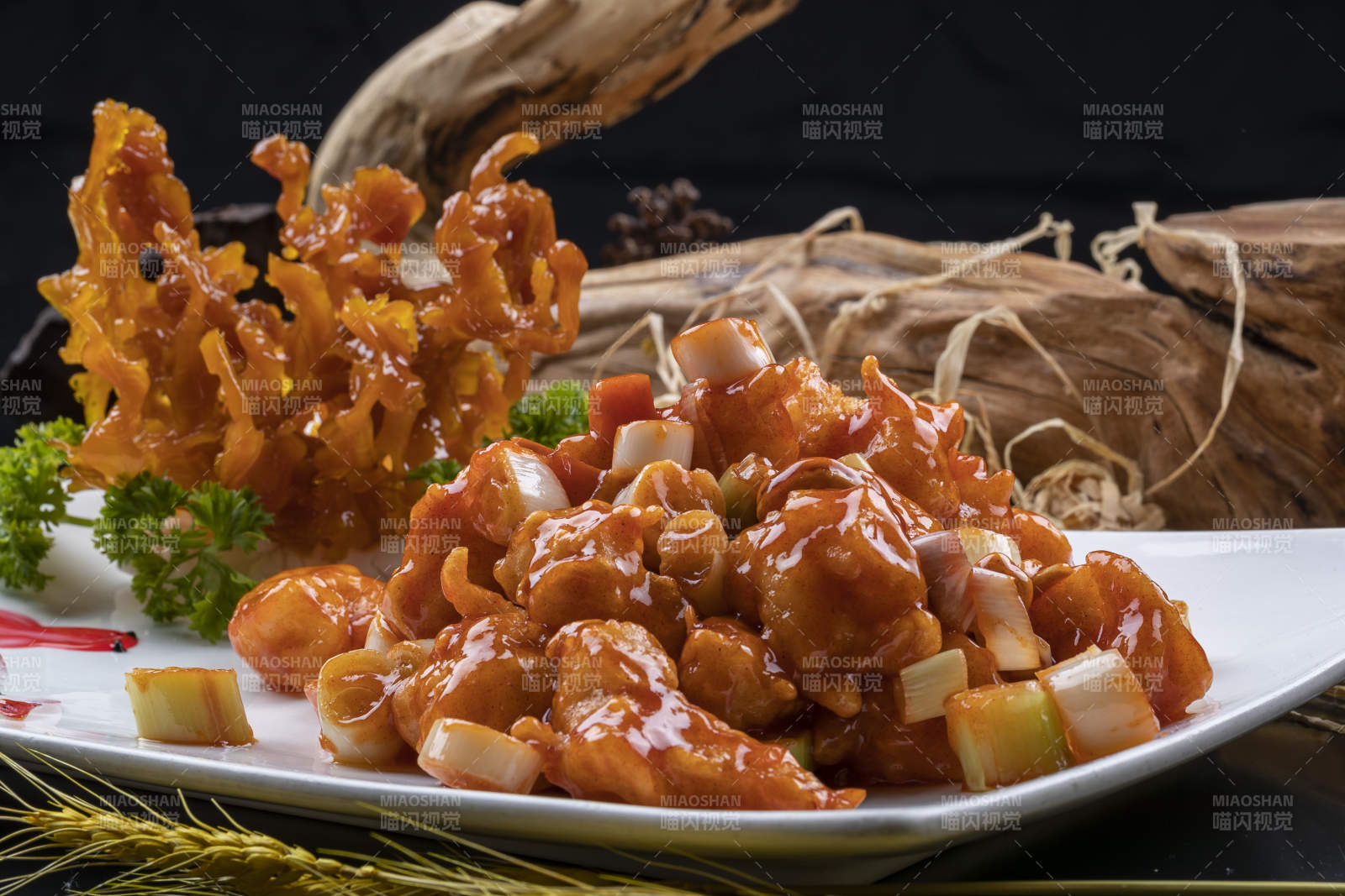 造型奇特的的宫保大虾球摆放在黑色背景上图片