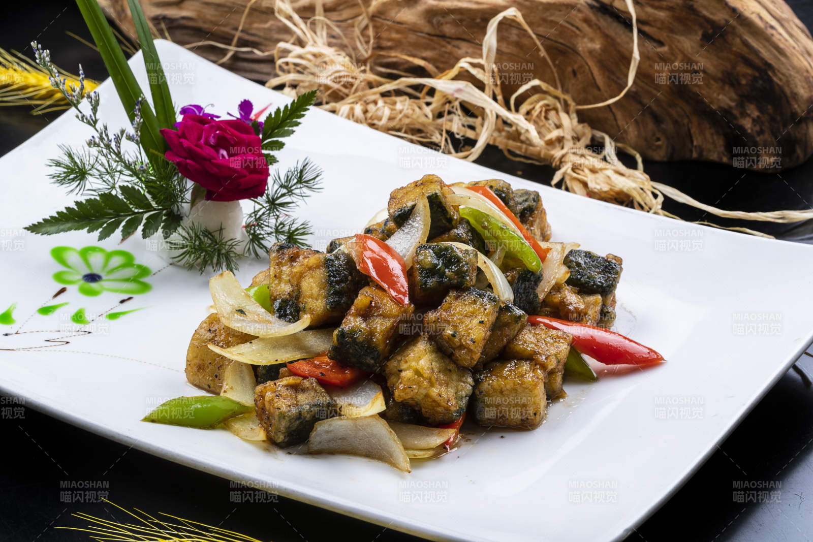 椒麻炸深海鱼块摆放在黑色背景上图片