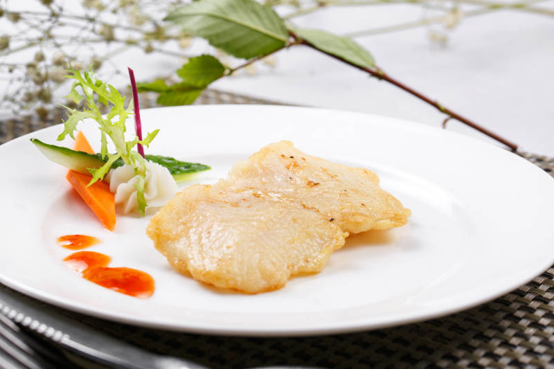 日式铁板煎石斑鱼摆放在餐垫上图片